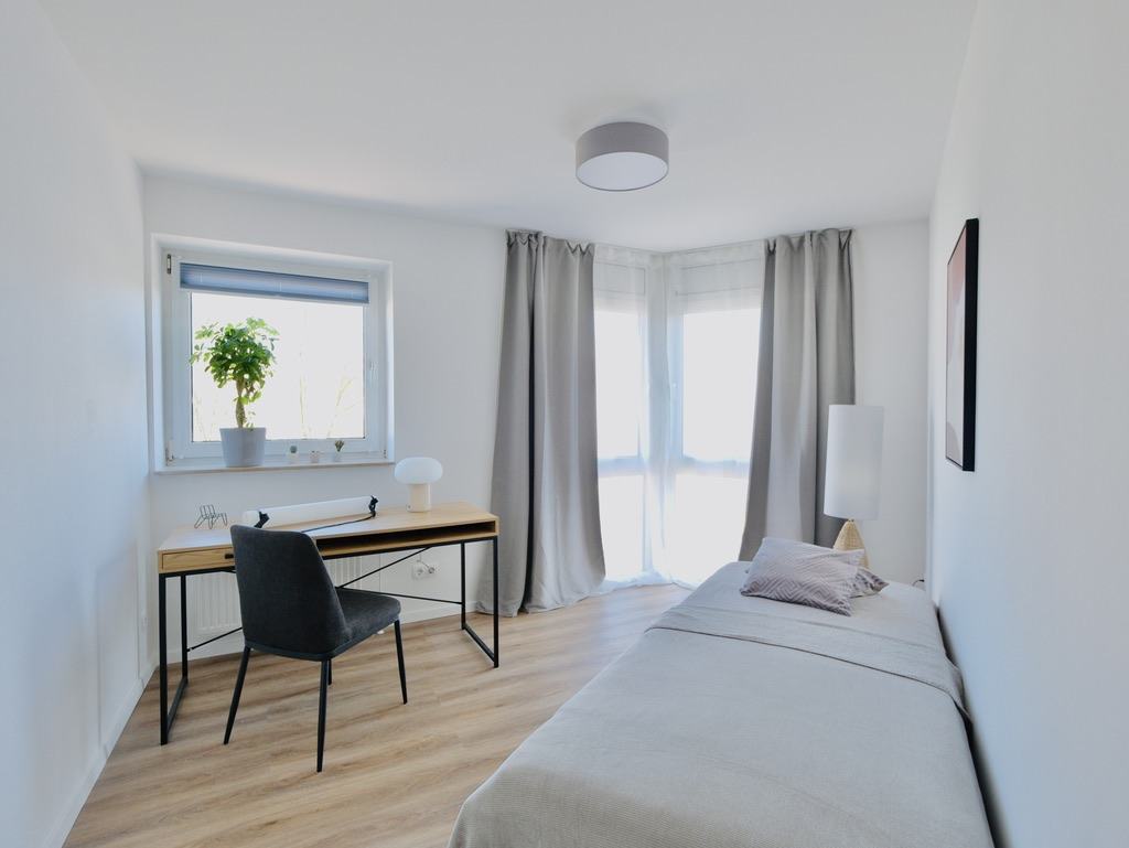 Helles möbliertes Zimmer mit Einzelbett und Schreibtisch für Studierende