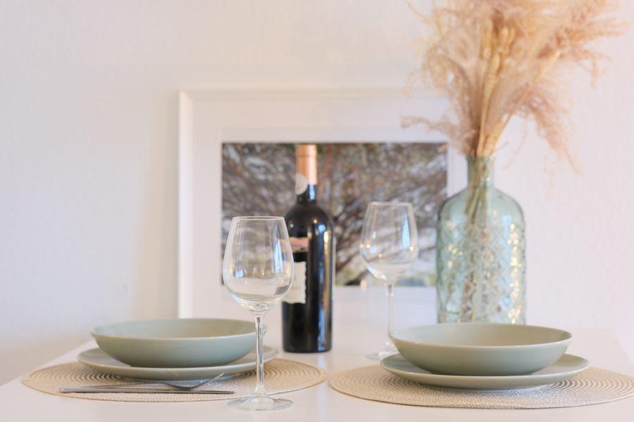 Gedeckter Tisch mit Wein und Trockenblumen – Staging-Detail
